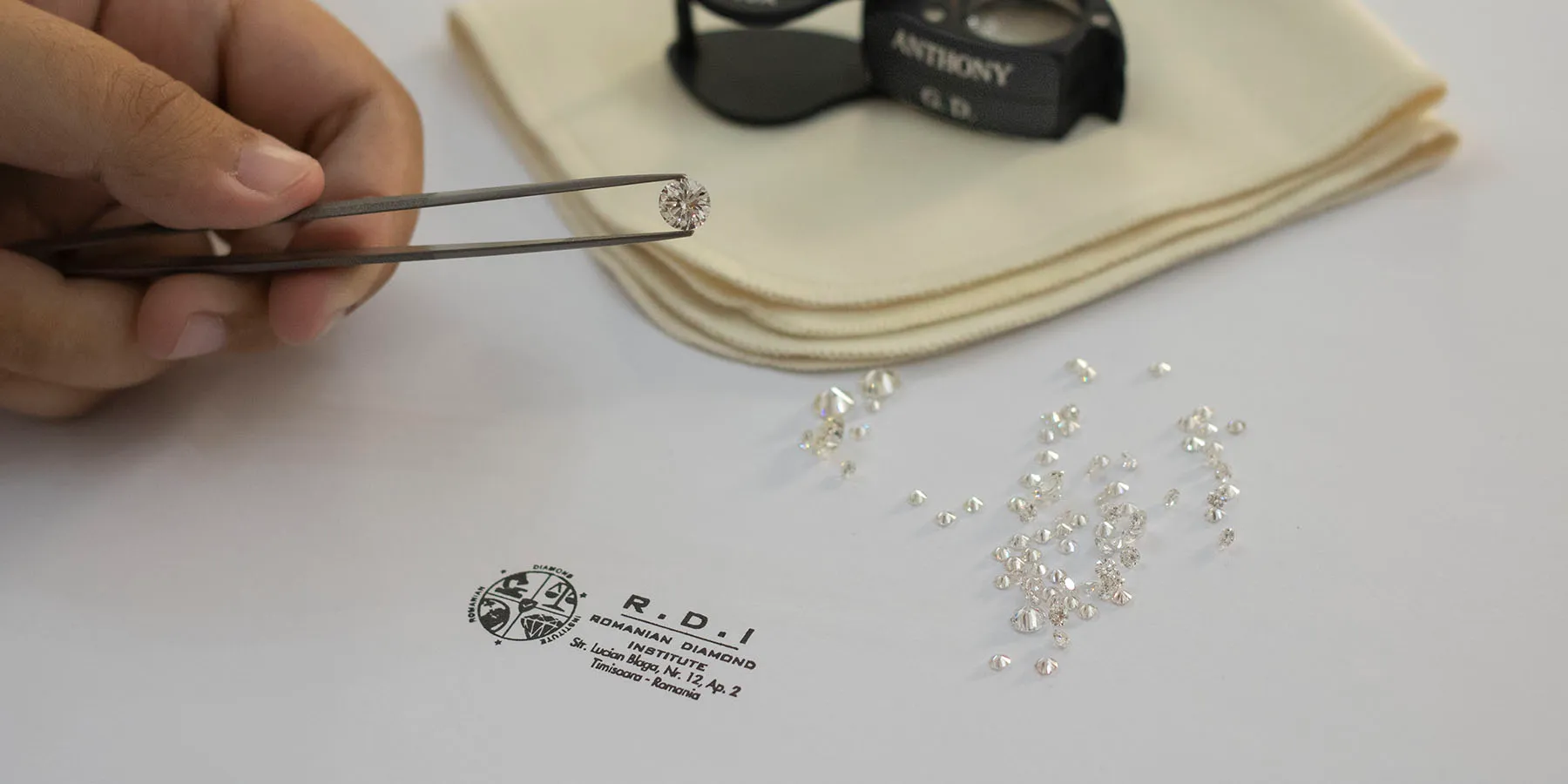 Loose diamonds and the R.D.I stamp on a grading table